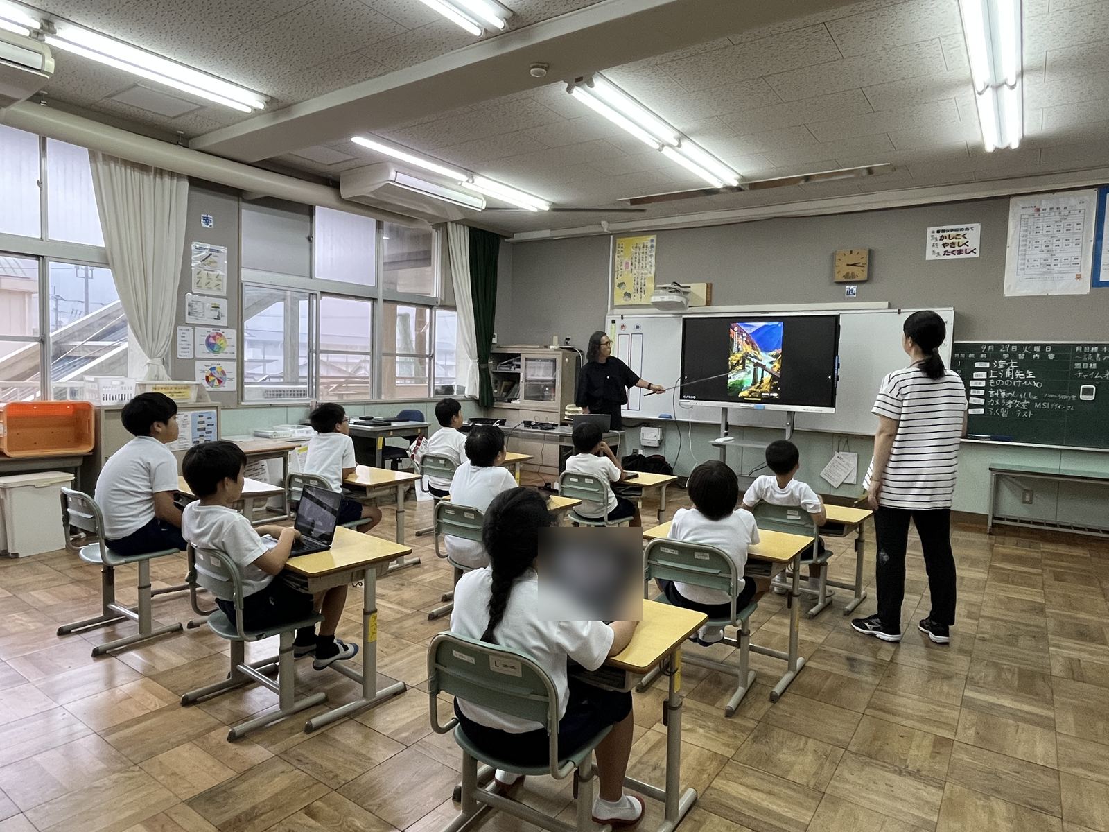 児童たちが自分のタブレットを見ながら講師の説明を聞いている様子